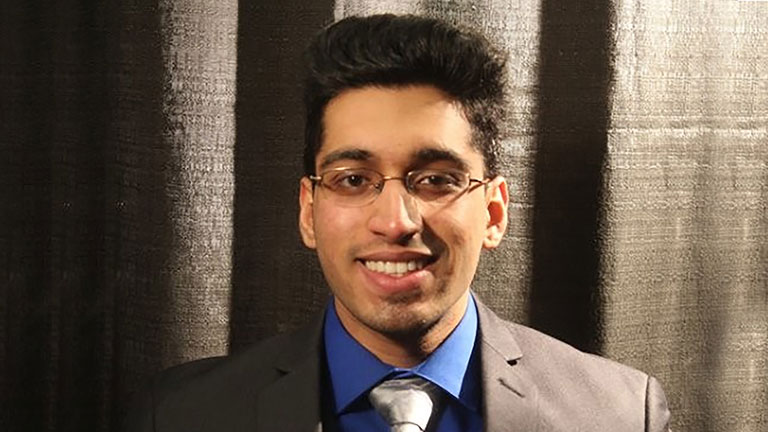 Headshot of a male performance marketing manager wearing a suit and tie.